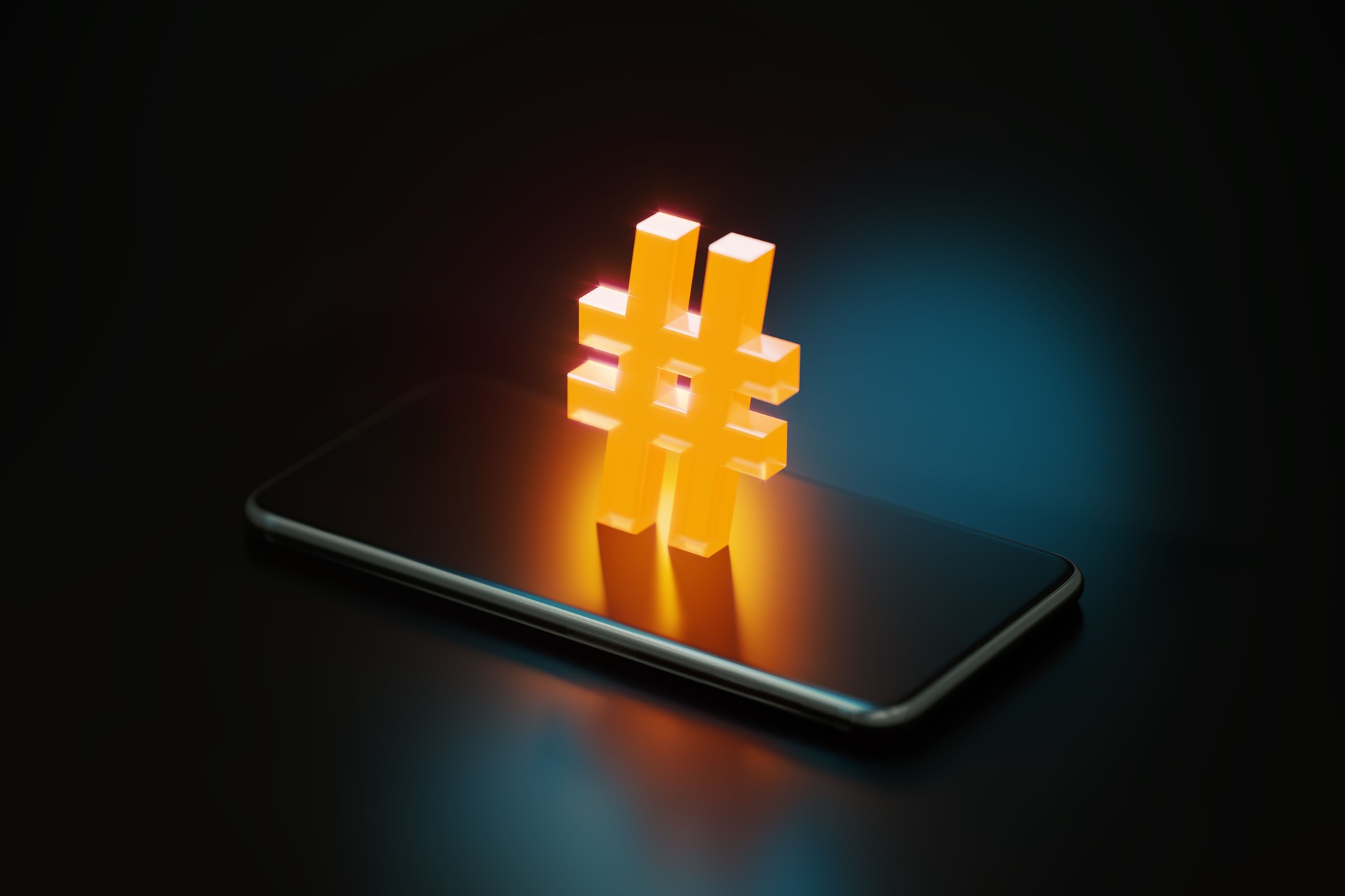 Gelbes Hashtag-Symbol, das über einem Smartphone auf schwarzem Hintergrund leuchtet